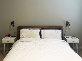 Our bed with nightstands and pendant lamps flanking either side