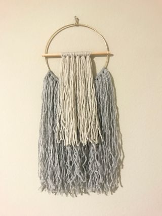 Wall hanging made of yarn, gold hoop, and dowel