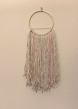 Wall hanging made of yarn and a gold hoop