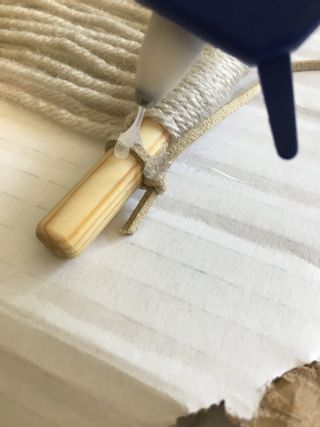 Hot gluing suede cord to dowel