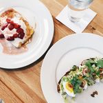 French toast with strawberries and cream and avocado toast with eggs and green toppings