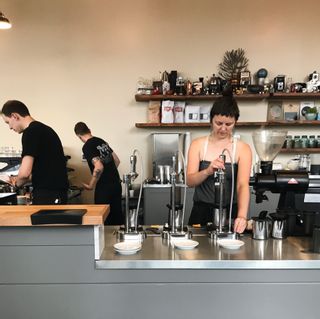 A barista making a drink inside Milstead & Co.